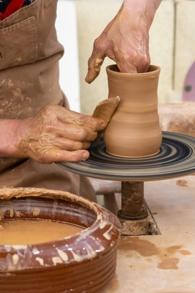 Potter shaping clay on a spinning wheel